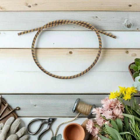 Gardening tools and flowers on wooden background with coiled rope