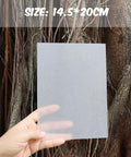 Hand holding a 25 Pcs Shrink Plastic Sheets For Crafts And DIY Jewelry Making Heat Shrink Blank Sheets 0.3mm Thick 14.5 By 20 Cm Size.