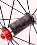 Close-up of carbon fiber hub on Road Bike Wheelset 700C With Carbon Fiber Hubs, Dope Double Wall Alloy Rims, featuring red accents