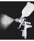 Mini Pneumatic Paint Sprayer Featuring 1.0 Mm Brass Flow Cap And Corrosion Resistant Needle For Straightforward Auto Detailing And Slick Finish Airbrush Jobs Built Tough For Top Shelf Durability, shown spraying.