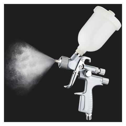 Mini Pneumatic Paint Sprayer Featuring 1.0 Mm Brass Flow Cap And Corrosion Resistant Needle For Straightforward Auto Detailing And Slick Finish Airbrush Jobs Built Tough For Top Shelf Durability, shown spraying.