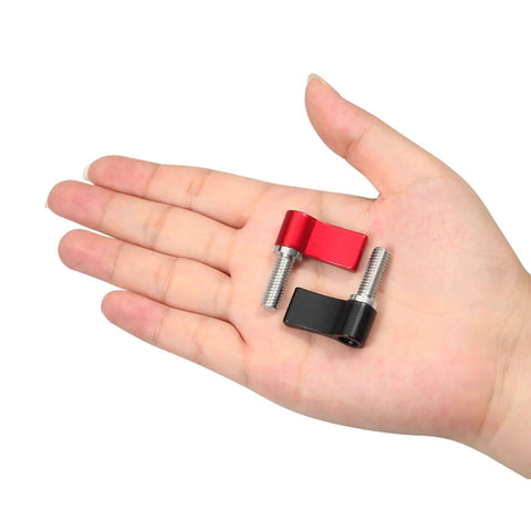 Close-up of a hand holding two thumb screws; 10 Pack M6 17mm Thumb Screws With Handle Red Rotating Knob Adjustable Lever Single Wing Easy Install No Tools Required Great For Furniture Decor Photography Gear And Electronic Equipment. One screw is black, and one is red, showing the rotating knob.