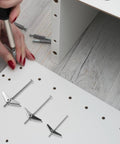 24 Piece Galvanized Steel Toggle Bolt Kit For Drywall Heavy Duty Anchors With Wing Nuts Easy Install And Secure Mounting For Furniture And Machinery Durable Wall Fixings, toggle bolts and a hand demonstrating use on wood panel