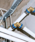 25 Pack Half Inch Brass PEX Fittings Set Includes 90 Degree Elbows For PEX Tubing Durable Potable Water Approved 2014 SDWA Compliant Easy Install Ideal For Home Plumbing Projects shown in plumbing setup with white PEX tubing.