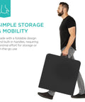Man carrying a black Four Foot Plastic Folding Table Heavy Duty Portable With Carry Handle Ideal For Indoor Outdoor Use