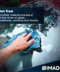 UNIMADE blue microfiber shop towel, 11x9 in, used to wipe a car windshield; close-up view