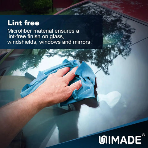 UNIMADE blue microfiber shop towel, 11x9 in, used to wipe a car windshield; close-up view