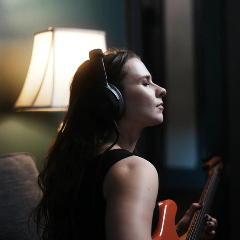 Guitarist wearing Dope Tone Wired Smart Guitar Headphone Amp With Custom Audio Drivers, playing electric guitar at home.