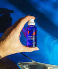 Front view of blue CARPRO CQUARTZ UK 3.0 ceramic coating bottle (50 ml) held in hand