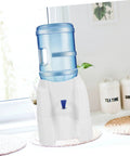 Portable Cold Water Dispenser For Desk And Office, Mini Water Cooler On Desktop Stand in a kitchen setting, heavy bottled water ready.