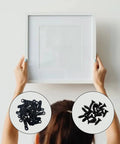 Picture frame hardware: front view of white square frame held by hands; 100 black turn-button fasteners and screws.