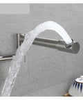 Foldable Wall-Mount Kitchen Faucet - Brushed Stainless Steel, Expandable & Retractable, water flowing from spout against a gray wall.