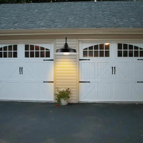 16 Inch Dome Barn Light Outdoor Wall Mount Sconce illuminating garage in farmhouse rustic industrial style at dusk