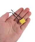 30 Piece Flexible Microfarad Capacitor Kit With 0.22uf Precision Testing Parts For Industrial Gear featuring a hand holding a yellow capacitor with black wires.
