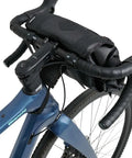 Close-up of a bike with Waterproof Bike Handlebar Bag Rolltop 9L Front Frame Storage With Secure Elastic Straps for MTB and gravel.