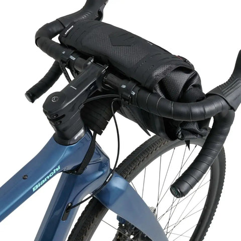Close-up of a bike with Waterproof Bike Handlebar Bag Rolltop 9L Front Frame Storage With Secure Elastic Straps for MTB and gravel.