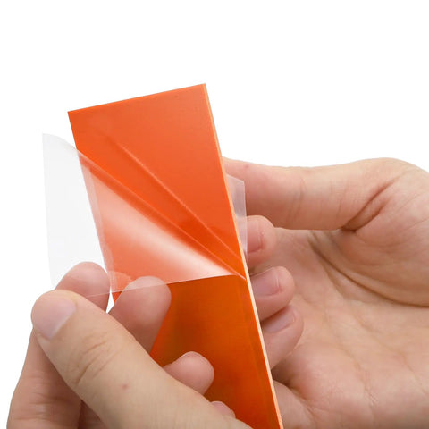 Hands peeling protective film off G10 Knife Handle Scale Sheets Set Pre Cut Spacer Material For Knife Making And DIY Projects And Tool Kits 20 Pieces In 10 Colors 6.3 Inches By 2 Inches By 0.03 Inches Pro Grade Durable Knife Scales For Folding Fixed Blade And Kitchen Knives