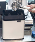 Electric Portafilter Cleaner Automatic Knock Box For Espresso Machines Clears Coffee Grounds, user cleaning portafilter above.