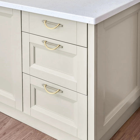 Brushed Brass And Brushed Nickel Cabinet Pulls 5 Inch Center To Center Curved Handles installed on white kitchen drawers.