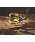 5 Inch Orbital Sander With 3.0 Amp Motor Delivers 12,000 OPM on wood surface, highlighting compact palm sander close to workpiece