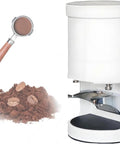 Heavy Duty Electric Coffee Tamper Featuring 58mm Universal Fit And Touchscreen Controls For Easy 5 To 30 Kilogram Pressure Settings Crafted From Rugged Aluminum And Stainless Steel For Tight Espresso Pucks That Crush Every Shot Without The Sweat next to coffee grounds and portafilter.