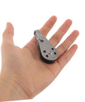 Hand holding a small stainless steel sailing pulley block with bearings, part of a 4 pack for marine rope pulleys kayak and boat anchor utility.