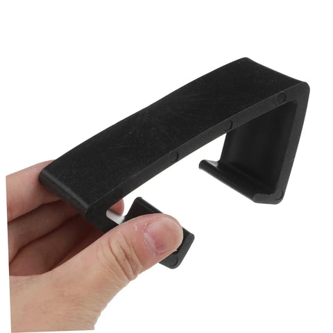Hand holding a black clip from Four Pack Wicker Sofa Clips For Patio Furniture Outdoor Couches Connectors To Secure Sectional Chairs In Place And Reusable Clips For All Types Of Furniture Easy Fit No Slip Grip Keeps Your Setup Tight And Looking Sharp.
