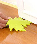 Person placing 4 Piece Leaf Shape Door Stopper Finger Protector Set Made From Durable PP Material to keep door open on wooden floor.