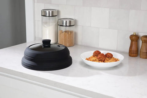 Mess Free Microwave Splatter Cover With Foldable Design for Quick Cleanup beside a plate of spaghetti on kitchen counter
