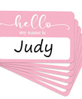Light Pink Hello My Name Is Stickers Set, 300 Pcs Name Tag Labels On A Roll, showing stack with "Judy" name