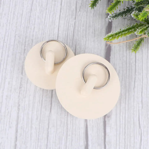 Close-up of two Rubber Sink Stoppers 4pcs with Hanging Ring for Bathtub Drains on a wooden surface.