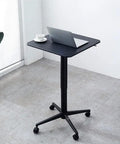 Heavy Duty Steel Height Adjustable Standing Desk Featuring No Fuss Manual Crank And Sturdy Casters Perfect For Your Home Office Grind Or Gaming Zone With Smooth Moving Ergonomic Design Built Tough, black top with laptop and coffee.