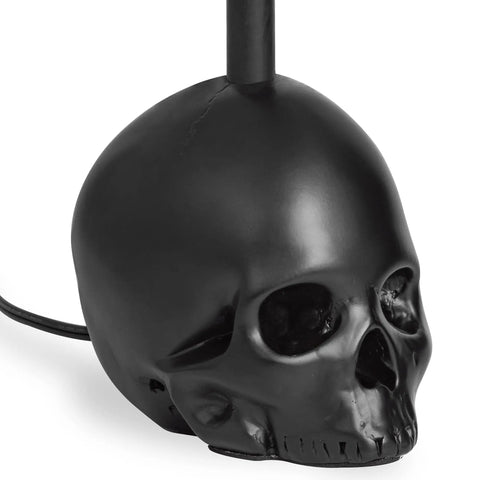 Close-up of Black Industrial Skull Lamp With Skeleton Decor For Gothic Bedroom Dope Handcrafted Cast Iron And Resin Skull Table Lamp Vintage Industrial Vibe UL Certified 18.5 Inches Tall 1 to 40W Bulb Not Included, focusing on the resin skull base.