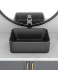 Square black vessel sink on modern vanity countertop with round mirror, not the Egg Shape Above Counter Vessel Sink In White Ceramic Porcelain 16 By 13 Inch Oval Vanity Lavatory Basin For Modern Bathrooms With Slick Easy To Clean Finish Not Included Faucet And Drain.