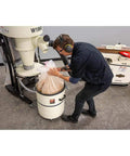 Man using Portable 2 HP Cyclone Dust Collector With 7 Inch Inlet, 20 Gallon Drum, 1023 CFM Airflow, 3450 RPM, Welded Steel Impeller