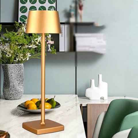 Gold cordless table lamp on marble table with books and decor, Cordless Table Lamps With 5200mAh Battery IP54 Waterproof Aluminum Alloy Touch Dimming Indoor Outdoor Use For Restaurants Buffets Bars Cafes Gold Long Lasting Battery Life For All Day Use Patio Ready.