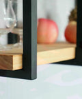 Close-up of Straight Up Heavy Duty Wrought Iron Floating Shelf Brackets with wood shelf holding apples and glassware.