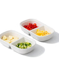 Set Of Two Divided Ceramic Dip Bowls With Stainless Steel Rims Zero Fuss Layout For Soy Sauce Vinaigrettes And Spice Mixes filled with sliced garlic, red chilies, green onions, and lemon.