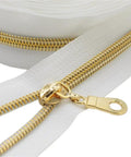 Close-up of Size Five Gold Nylon Coil Zipper With White Tape By The Yard, 10 Yards Of Continuous Zip, Includes 25 Gold Pulls
