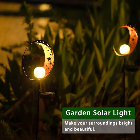 Solar Powered Garden Light With Crackle Glass Moon Ball On A Metal Stake illuminating a garden pathway at night