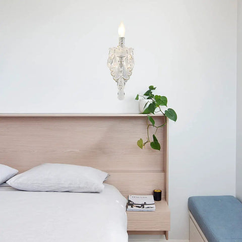 1 Light Distressed White Crystal Wall Sconce With Candle Style Vintage Farmhouse Vibe in a bedroom setting