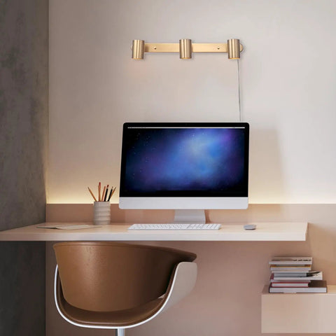 Three Light Plug-In Track Lighting In Matte Brass With Adjustable Heads, 15-Foot Cord, mounted on wall above desk
