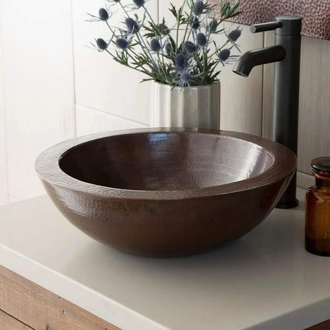 Premium Slick Vessel Bathroom Sink Made From Tough 16 Gauge Hammered Copper With An Antique Bronze Finish view on countertop.
