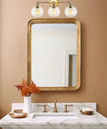 22 Inch Modern Three Light Vanity Bathroom Light With Clear Glass Globe Shades And Warm Brass Finish Above Sink