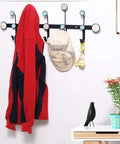 Round Dot Wrought Iron Wall Hook Absolute Game Changer For Entryway Storage, holding a red jacket and hat, displayed on a wall.