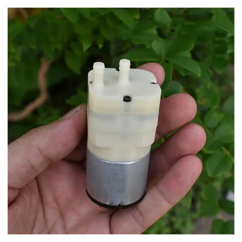 Hand holding 12V Diaphragm Vacuum Pump With 33mm Head, Lightweight Air Pressure Pump For DIY Inflator And Aquarium Tank Aerator, High Flow Performance, 5mm Inlet And Outlet, Compact Micro Motor