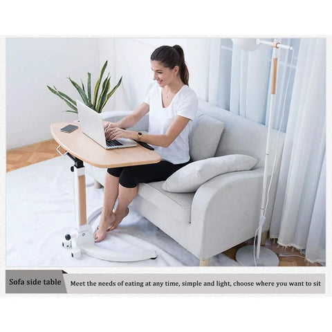 Mobile Height Adjustable Standing Desk With Sturdy Silent Rolling Casters And Flexible Tray Surface Perfect Over Bed Support For Bed Rest Or Kickback Home Office Lounge, used by a woman on a sofa.