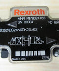 Close-up of solenoid directional valve R978024163 4WE6Q62/EG24N9DK24L/62 label with Bosch Rexroth branding and technical specifications.