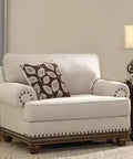 Elegant cream loveseat with dark wood trim, decorative pillows, and side table for living room decor.