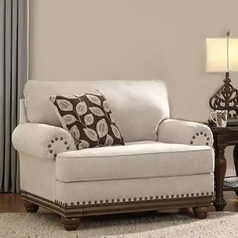 Elegant cream loveseat with dark wood trim, decorative pillows, and side table for living room decor.